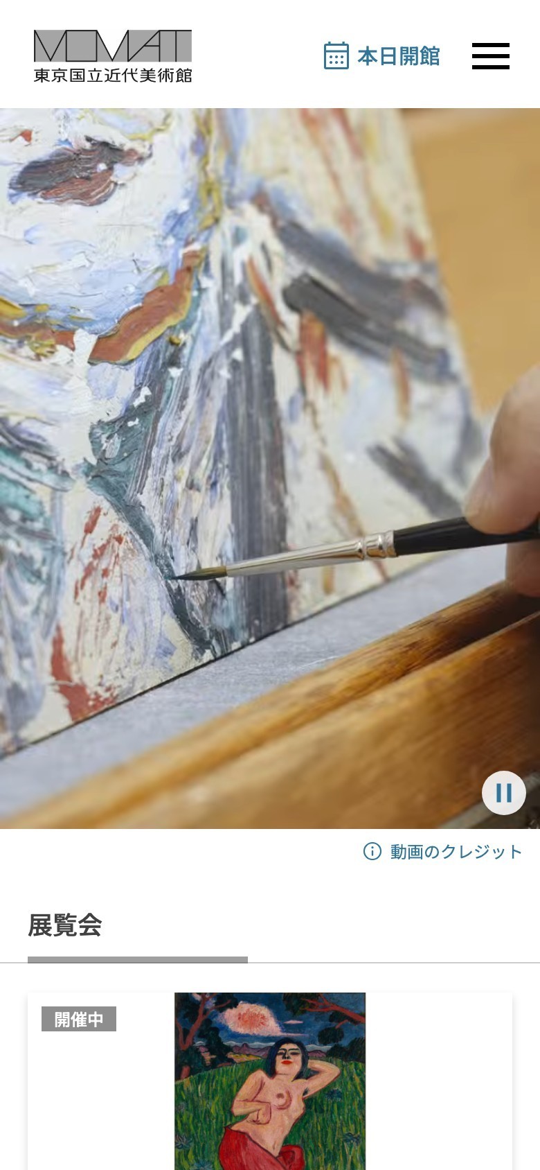 東京国立近代美術館の公式サイトをスマートフォンで表示した画面。ヘッダーには本日開館の表示とメニューボタンがあり、メイン画像には絵画の修復作業の動画、その下に展覧会セクションと開催中の展示が続く